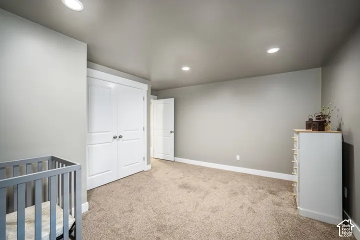 Plush carpet flooring, recessed ceiling lighting, two-panel interior doors, and crisp white trim