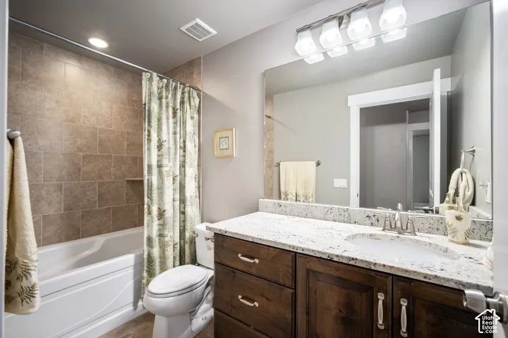 Spa-inspired master bathroom featuring a double vanity with marble-look countertops, rich wood cabinetry, and polished nickel hardware