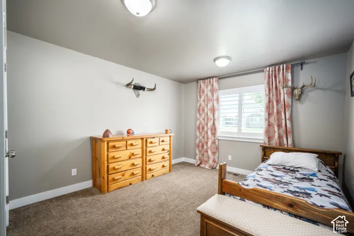 Spacious bedroom featuring carpet flooring, recessed ceiling lighting, and large windows with patterned curtains