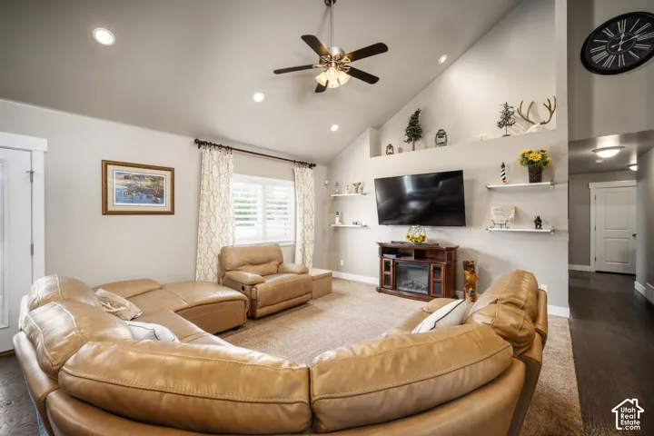 Vaulted ceiling, recessed lighting, ceiling fan, wood-finish flooring, and built-in shelving