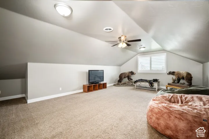 Carpeted floor, sloped ceilings, ceiling fan, recessed lighting, window with white louvered shutters