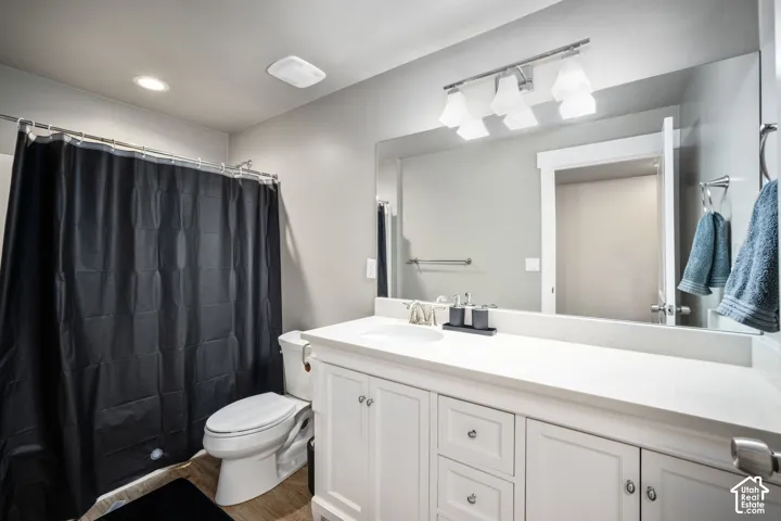 Bathroom featuring a white vanity with panel cabinetry and silver-tone hardware, a rectangular undermount sink, and a large wall-mounted mirror