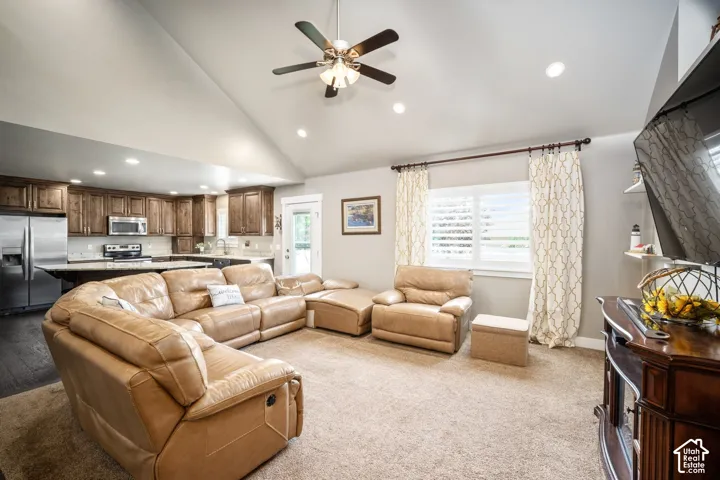 Vaulted ceilings with a ceiling fan, recessed lighting, wood-finish flooring, white plantation shutters, and stainless steel appliances