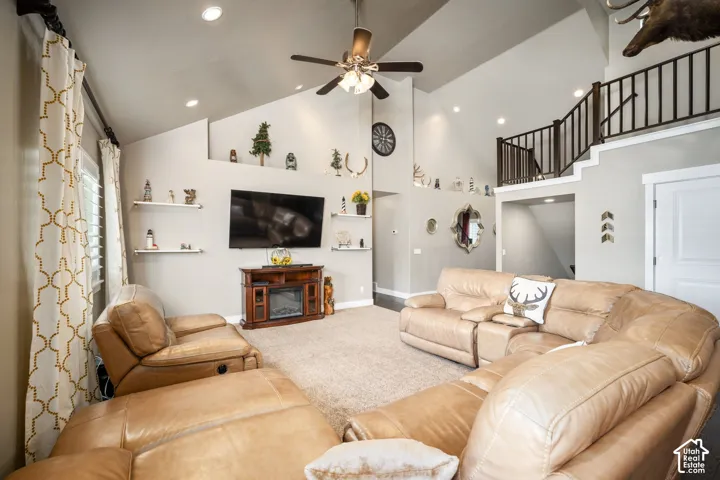 Spacious great room with soaring ceilings, ceiling fan, and recessed lighting