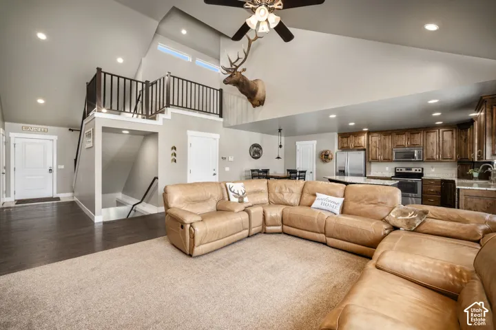 Vaulted ceiling with a ceiling fan, recessed lighting, and upper windows