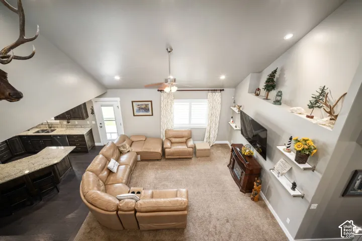Open concept living area featuring a ceiling fan, recessed lighting, and wall-mounted shelving