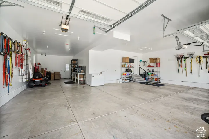 Spacious garage with concrete flooring, automatic garage door openers, and built-in shelving