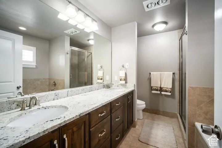 Spa-inspired master bathroom featuring a dual-sink vanity with wood cabinetry, white quartz countertop, and polished chrome fixtures