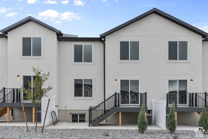 Stucco exterior with multiple windows, two sliding glass doors, and two exterior light fixtures