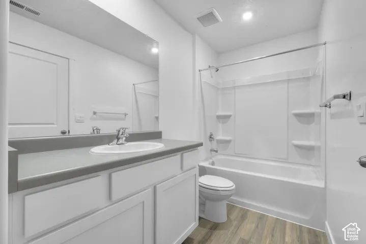 White vanity with a gray countertop, an undermount sink, and chrome fixtures