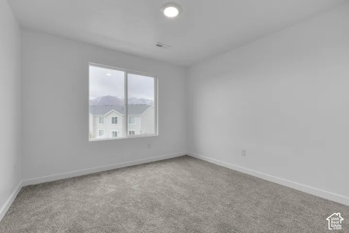 Recessed ceiling light, carpeted flooring, white trim, and a window with a mountain backdrop
