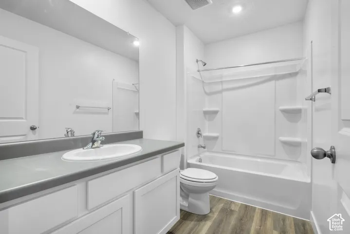 White vanity with a gray countertop, an undermount sink, and a chrome faucet