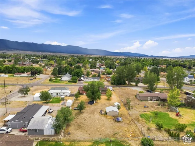 Expansive lot featuring mature trees, a detached storage shed, and mountain scenery
