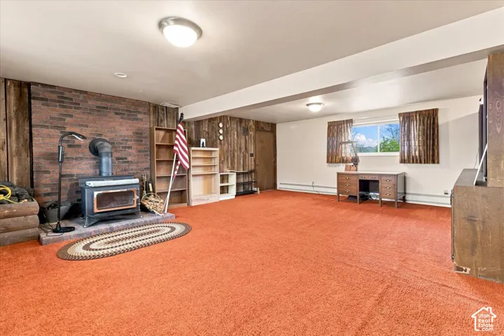 Wood-burning stove with a brick-finish surround, wood paneling, and wall-mounted light fixtures
