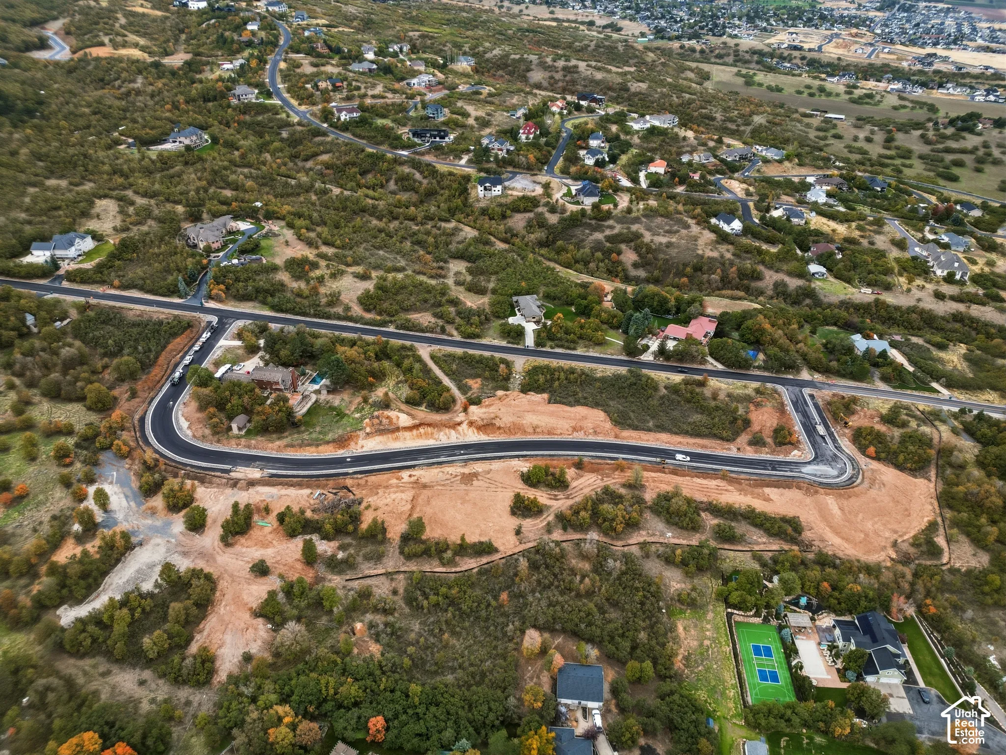 Expansive land parcel featuring developed roadways and surrounding mature trees