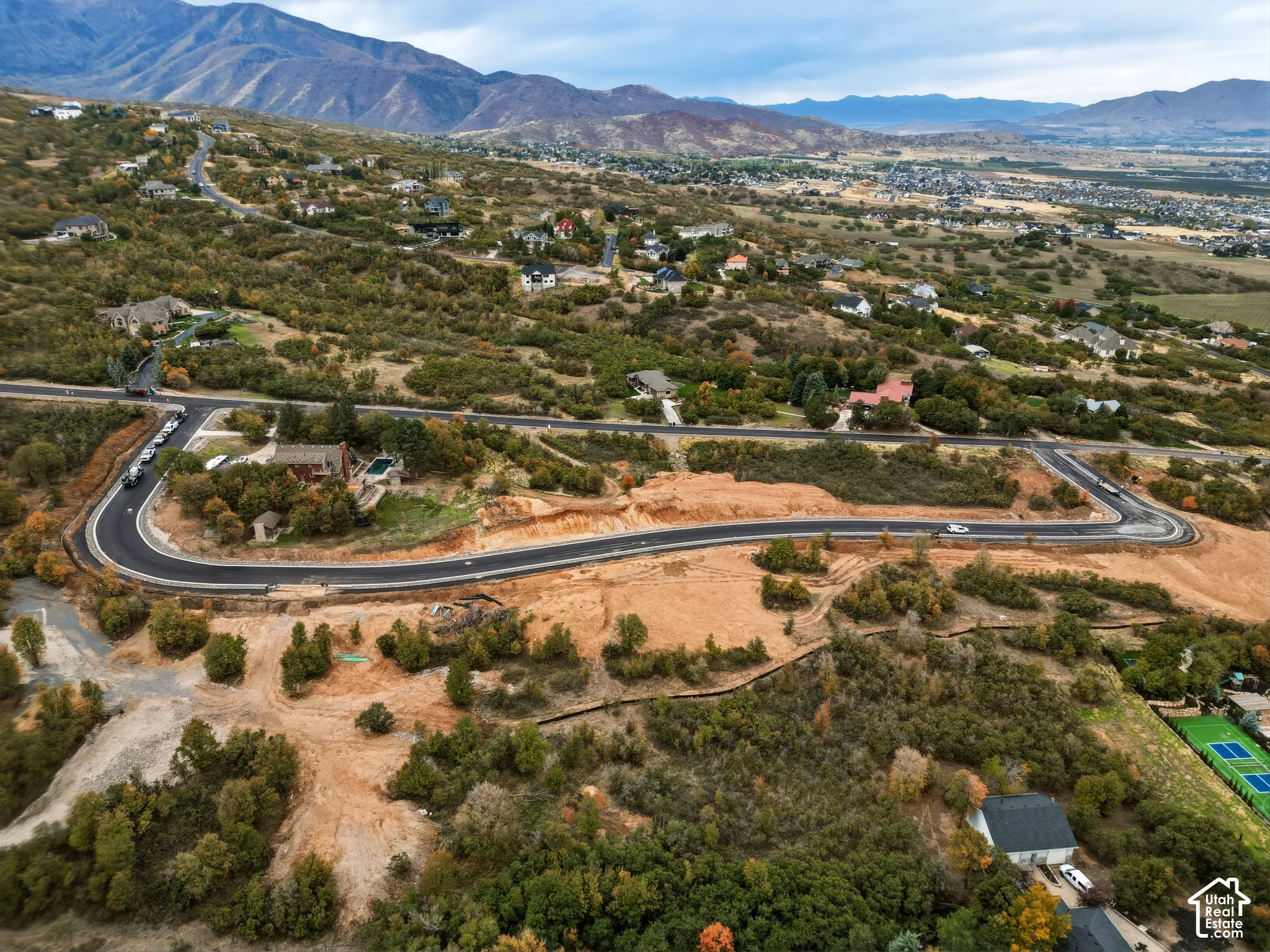 Mountainous landscape with developed and undeveloped parcels, featuring paved roadways and established residential structures