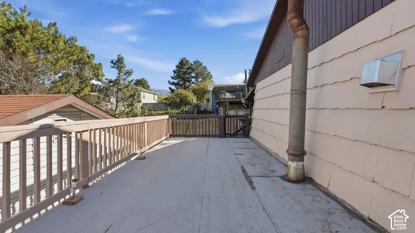 Elevated exterior deck featuring a wood-finish railing and vertical wood siding