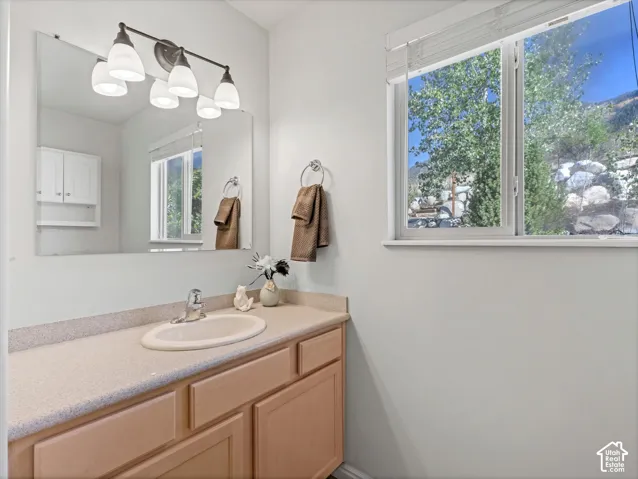 Vanity with an integrated sink, polished chrome faucet, and wood-finish cabinetry