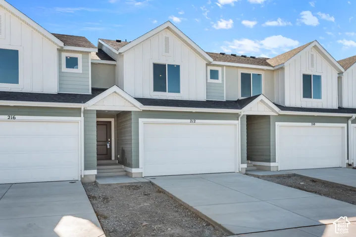 Modern townhome exterior featuring light green siding and white board and batten accents