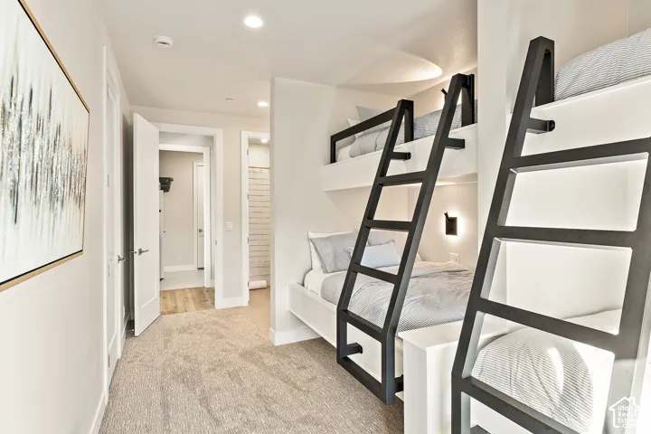 Integrated bunk beds with black metal ladders and recessed lighting