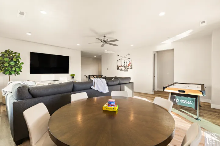 Recessed lighting, wood-finish flooring, ceiling fan, and white wall finishes