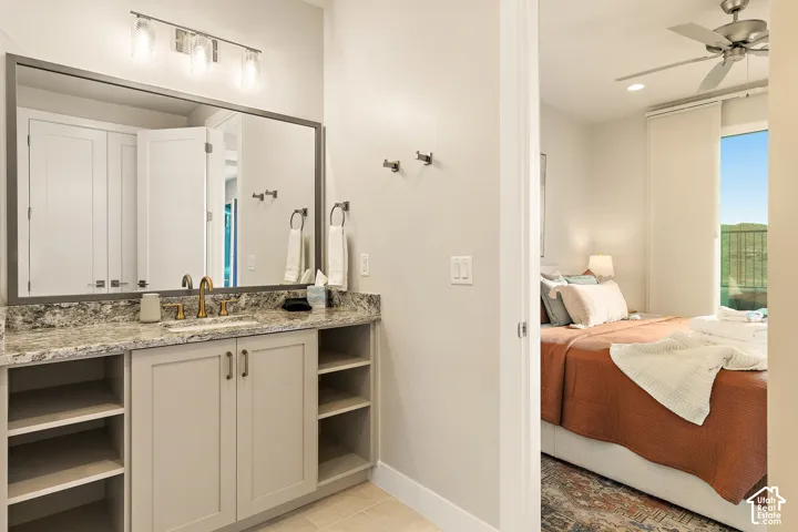 Vanity with stone-finish countertop, undermount sink, and brass-finish faucet