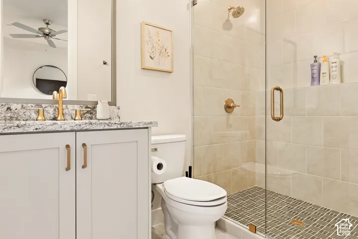 White vanity with gold-toned hardware, speckled countertop, and gold-toned faucet