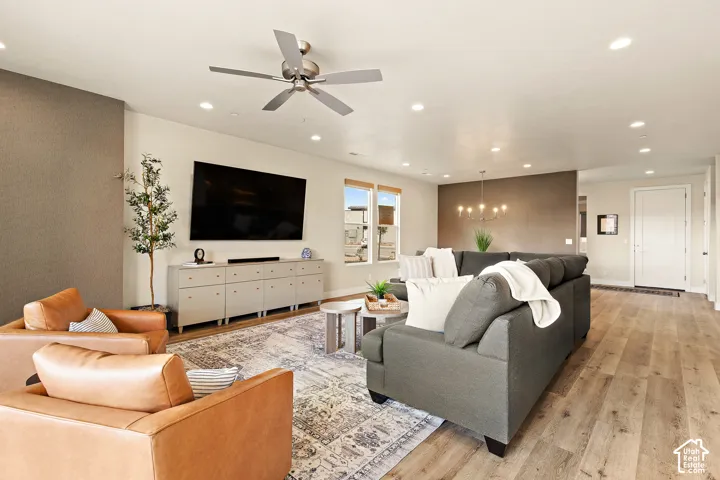 Expansive living area with wood-finish flooring, recessed lighting, and a modern ceiling fan