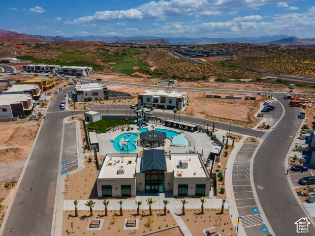 Community recreation building with a large swimming pool, surrounding lounge areas, and paved roadways