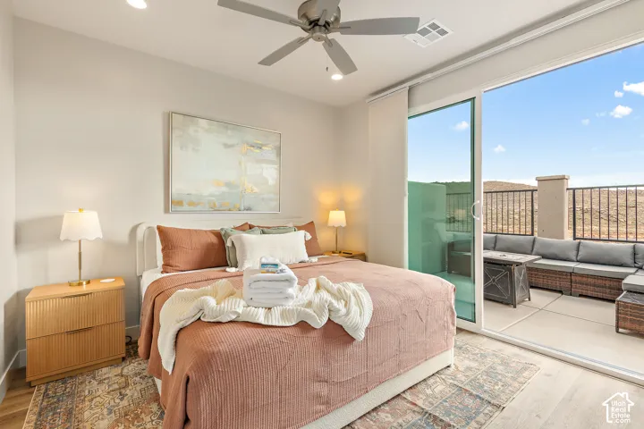 Recessed lighting, ceiling fan, wood-finish flooring, sliding glass door, and a private patio with metal railing