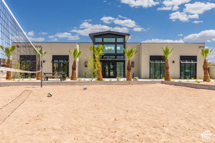 Sand volleyball court with a net, flanked by palm trees