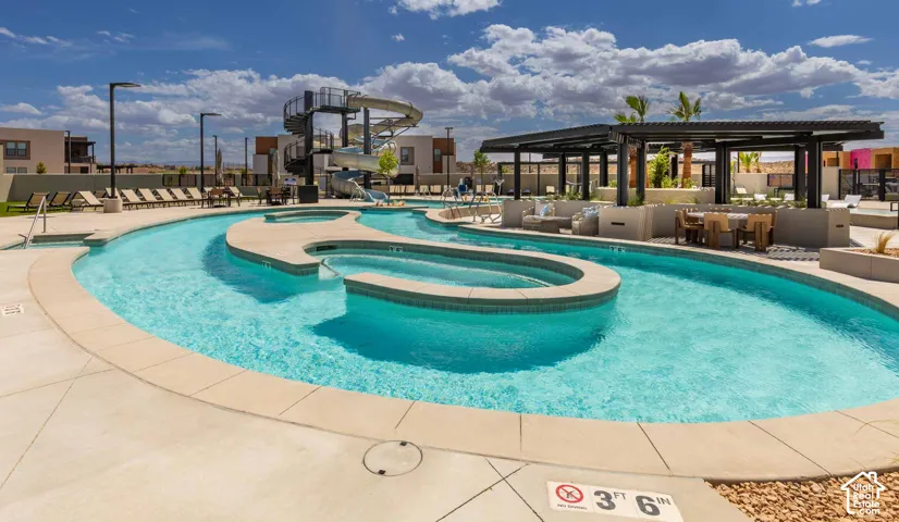 Lazy river with integrated hot tubs, expansive concrete decking, and a multi-story waterslide