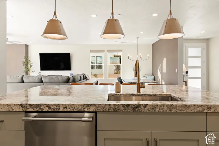 Kitchen island with a granite countertop, undermount sink, and brass-finish faucet