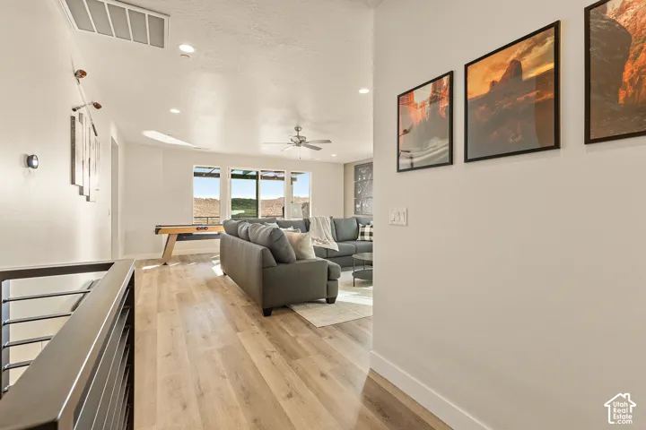Open-concept living space with wood-finish flooring, a contemporary ceiling fan, and recessed lighting