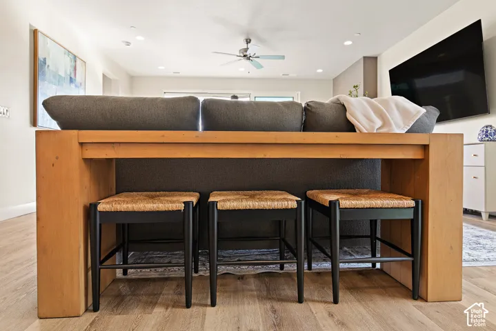 Open-concept living space with wood-finish flooring, recessed lighting, and a ceiling fan