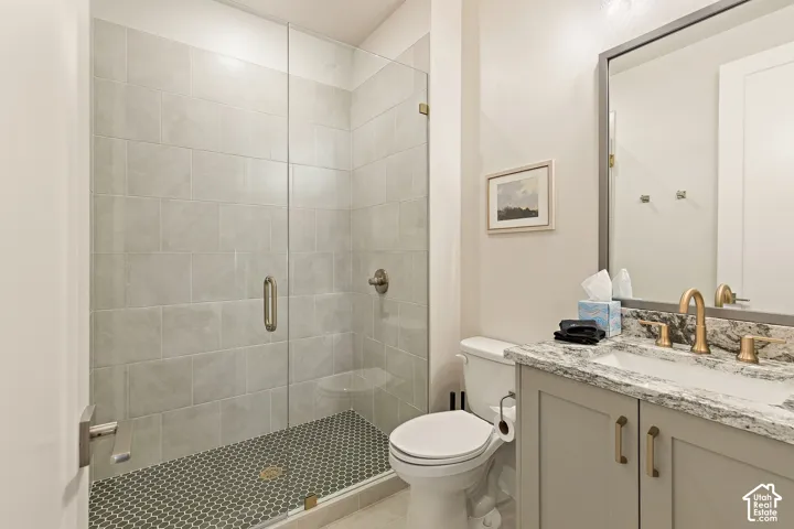 Glass-enclosed shower with subway tile surround and hexagonal floor tiles
