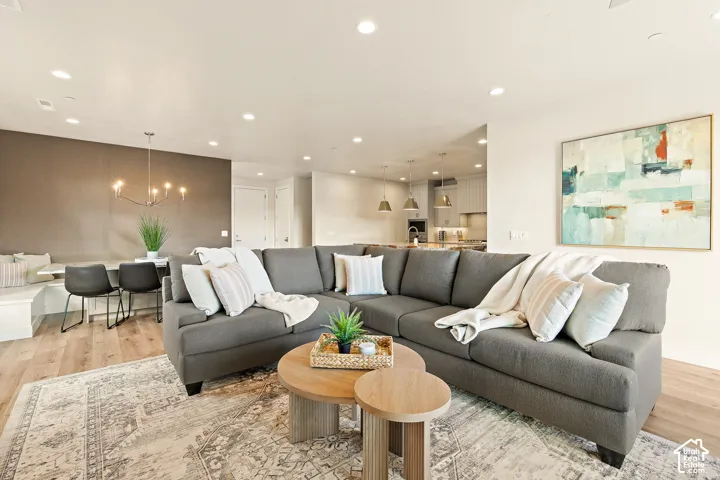 Recessed lighting, wood-finish flooring, and a modern chandelier