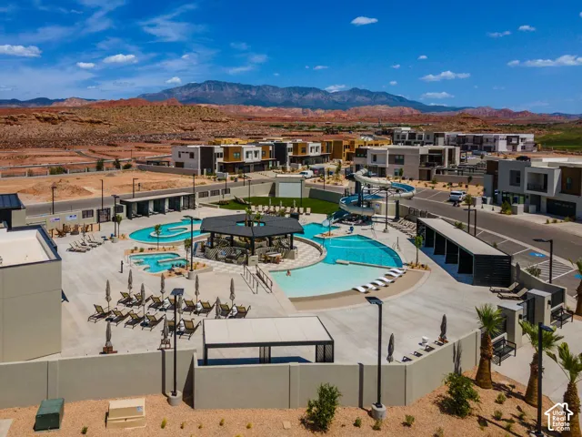 Expansive outdoor pool area featuring multiple swimming pools, a water slide, and a shaded cabana