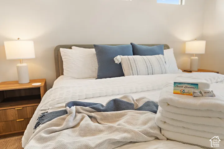 White textured bedding with a neutral upholstered headboard