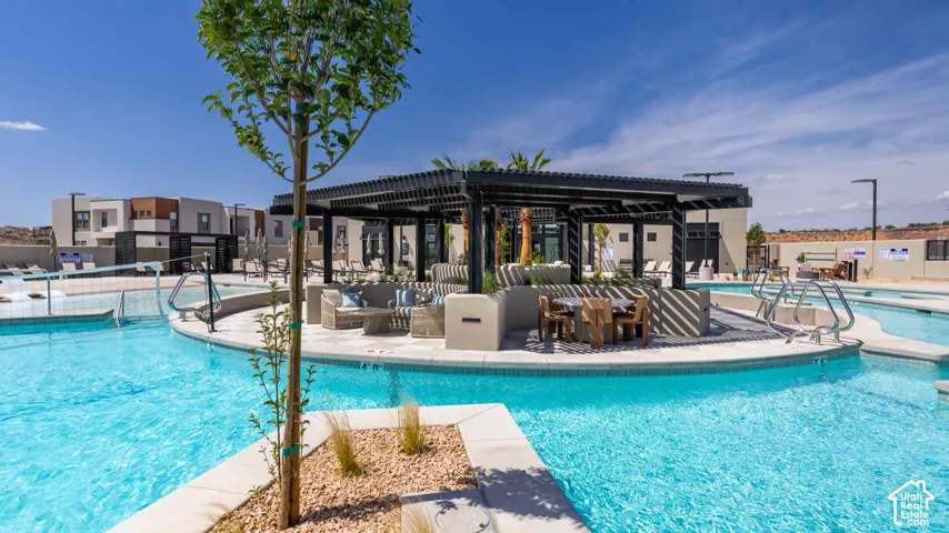 Expansive swimming pool with integrated tanning ledges, a dedicated lap lane, and a pergola-covered lounge area