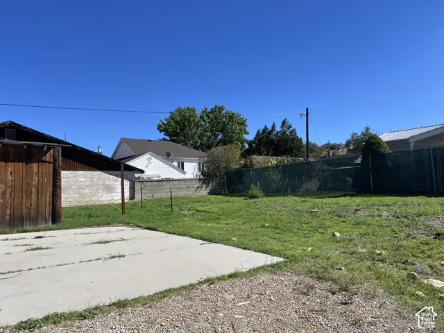 Expansive lot featuring a concrete pad, gravel area, and chain-link fencing