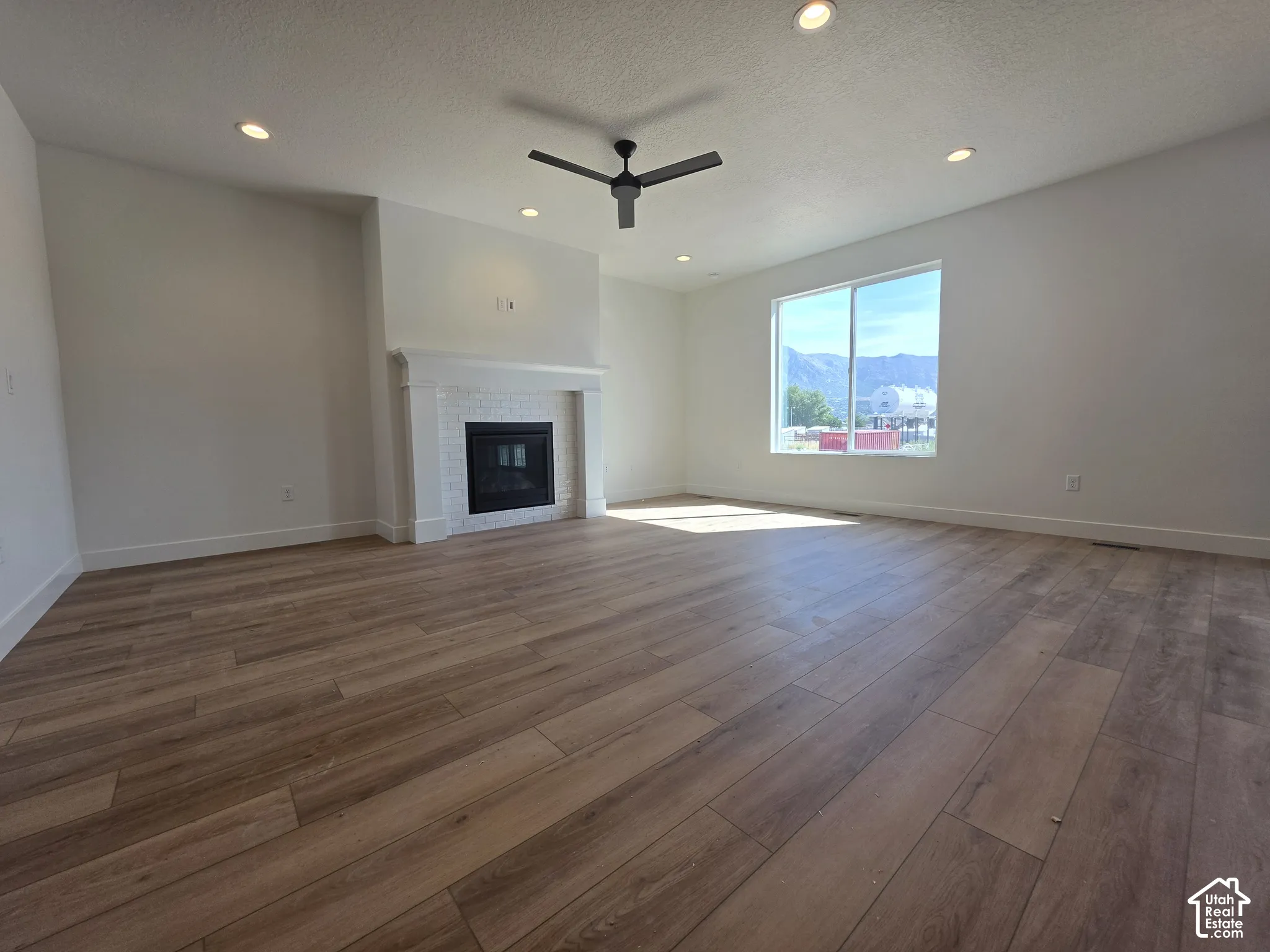 Spacious interior with wood-finish flooring, recessed lighting, and a modern ceiling fan