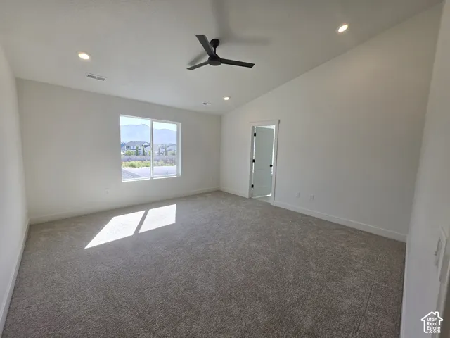 Recessed lighting, sloped ceiling, window, carpeted flooring, and a modern ceiling fan