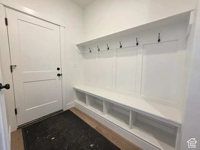 Built-in mudroom bench with storage cubbies, wall hooks, and upper shelf