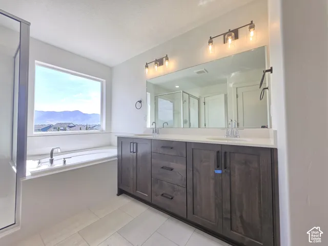Dual vanity with wood-finish cabinetry, white countertop, and individual sinks