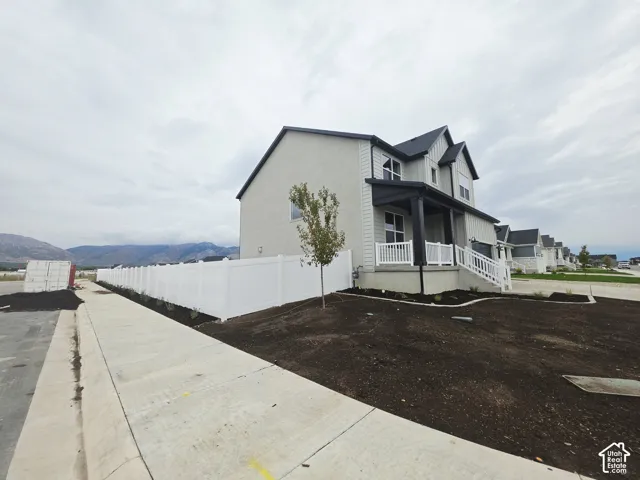 Modern exterior with a covered porch, white railing, and dark trim accents