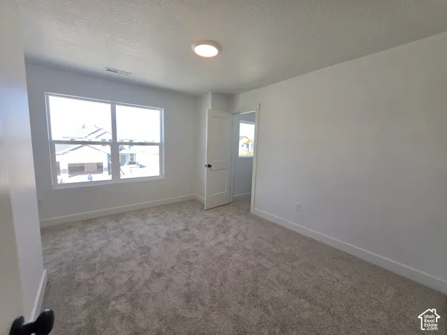 Carpeted flooring, white walls, and a large window