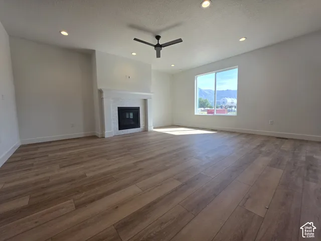 Spacious interior with wood-finish flooring, recessed lighting, and a modern ceiling fan