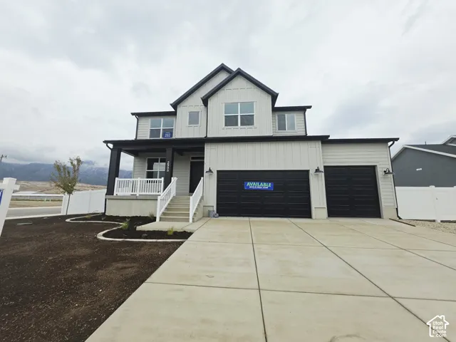 Two-story exterior with a covered porch, an attached two-car garage, and a concrete driveway