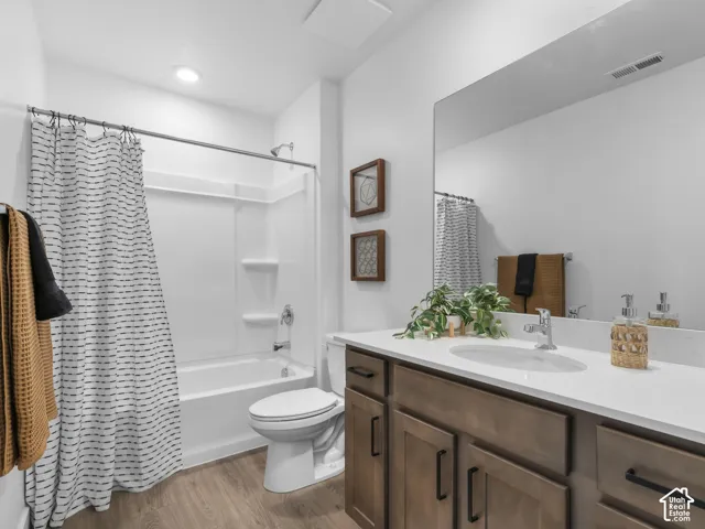 White vanity with integrated sink, wood-finish cabinetry, and a large wall-mounted mirror